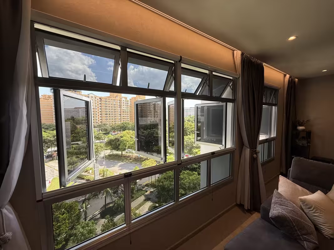 A bright Singapore living room with a retractable window mesh letting in fresh air