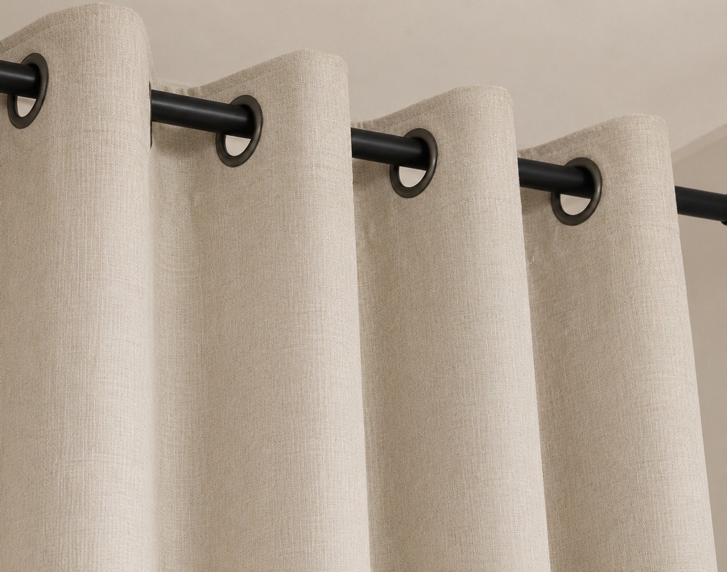 Eyelet curtains with metal ring openings threaded on a curtain rod