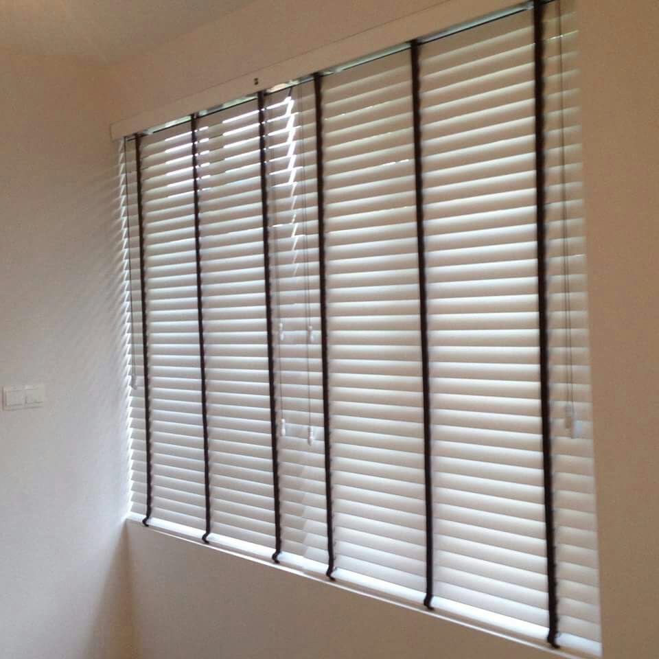 Venetian blind fitted across a large living-room window with the slats tilted open