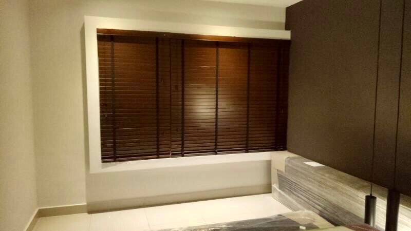 Aluminium Venetian blind angling daylight across a bright room