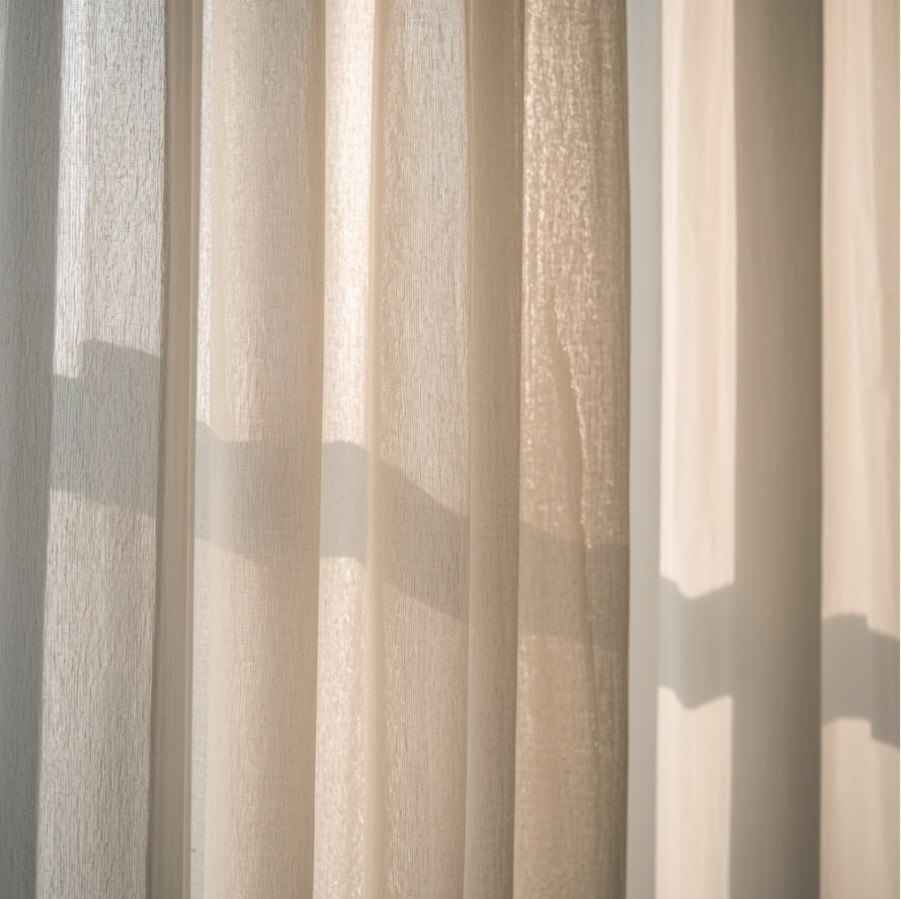 Privacy sheer curtains drawn across a window, filtering daylight while keeping the room private